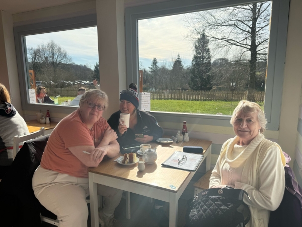 friends sit in a café drinking tea and coffee