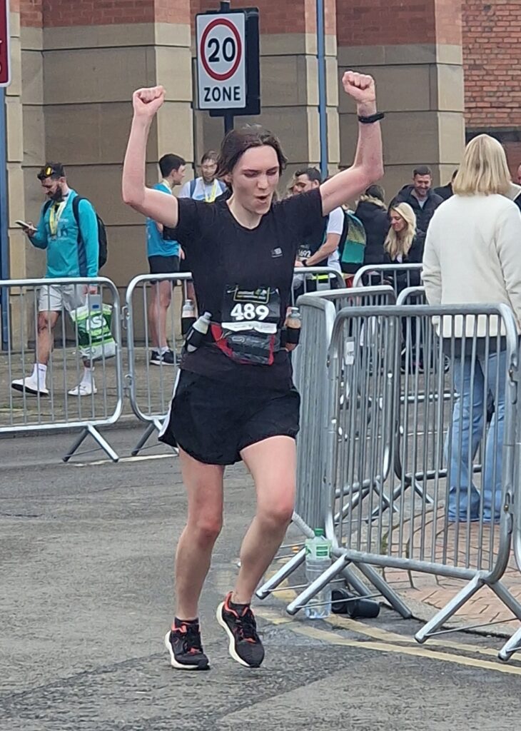 A runner cheers as they finish the Stafford half-marathon